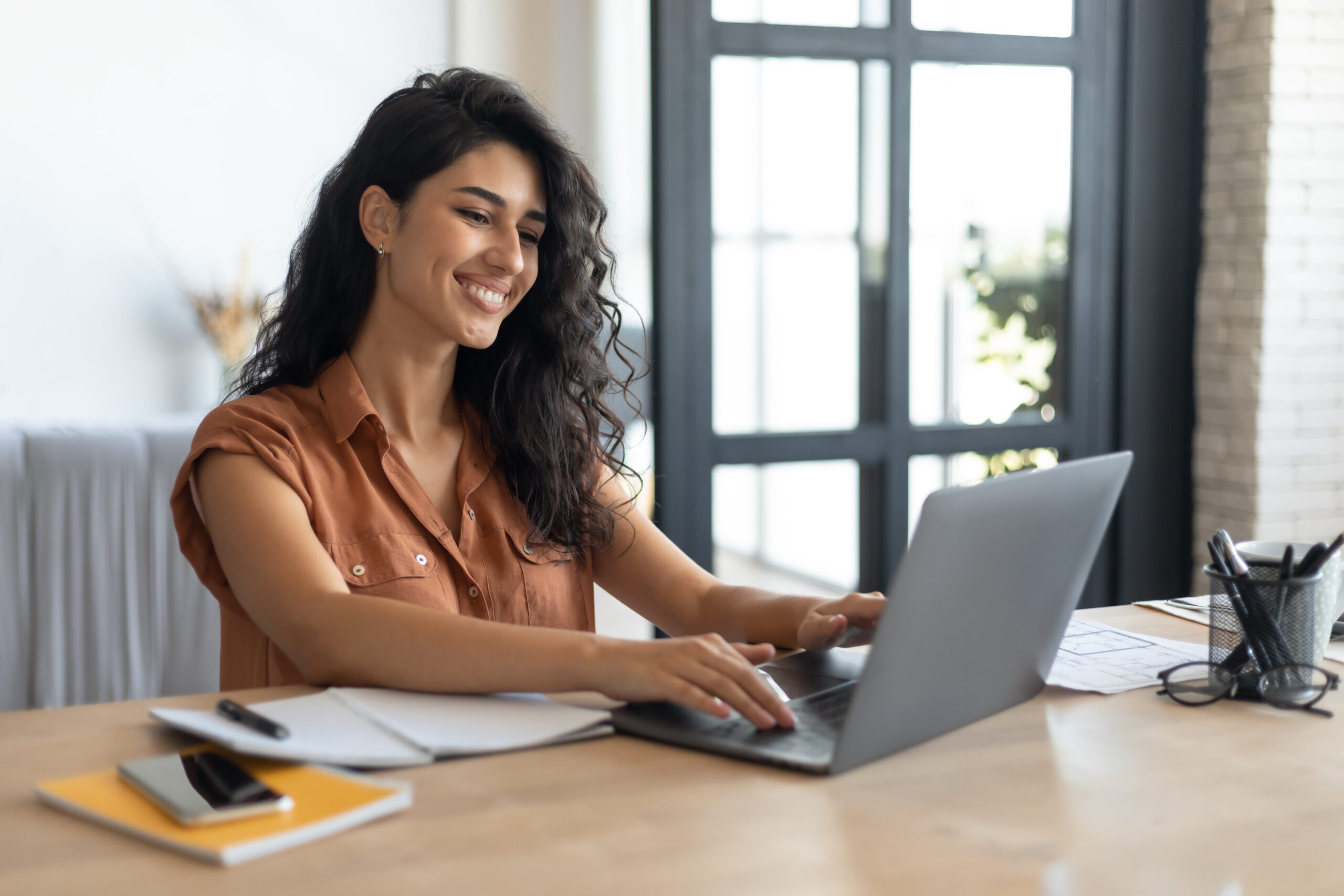 WordPress vs Joomla vs Wix vs Squarespace (2025): Which Website Builder Is Best for SEO and Growth? A woman taking notes on what she thinks determines the best website builder for SEO.